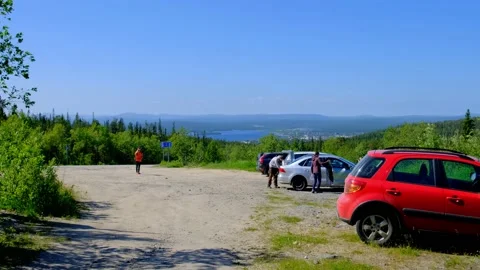 Tourists return to the parking lot after sightseeing in the mountains Stock Footage 157779261