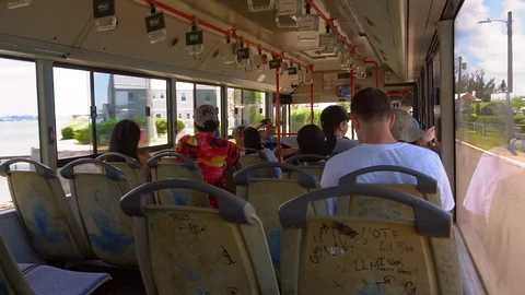Tourists riding on a bus using public transportation to get around the island Stock Footage 129394700