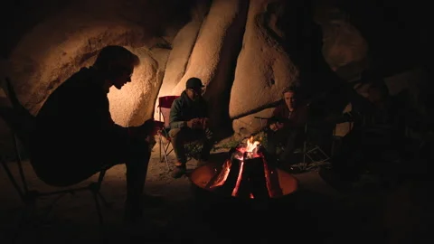 Tourists sharing stories while relaxing around warm bonfire Stock Footage 237920730