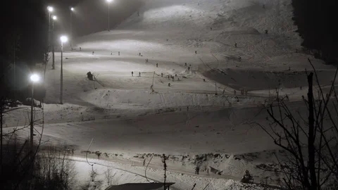 Tourists Skiing Down on a Ski Resort Slope in the Evening Video stock 124276525