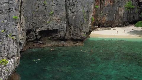 Tourists snorkel on Phi Phi Ley island, tourists snorkel in the famous Maya Bay Stock Footage 258740612