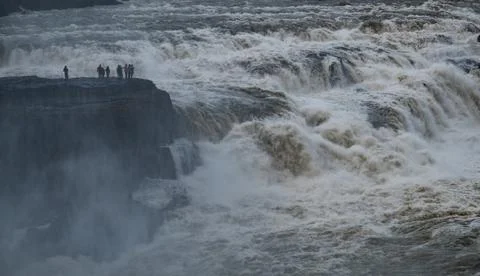 Tourists standing on a cliff at gullfoss, e waterfall and glacial river hvita Stock Photos