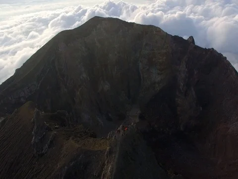 Tourists standing at the edge of Agung volcano crater in Bali, Indonesia Stock Footage 80582955