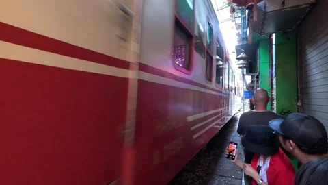 Tourists standing extremely close to a red train, Hanoi Train Street in Vietnam. Stock Footage 335796060