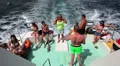 Tourists at the stern of the ship during a cruise along the sea shore HD Footage