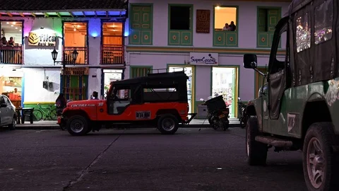 Tourists stroll in the evening in the square of salento in colombia, jeep willys Stock Footage 126122771