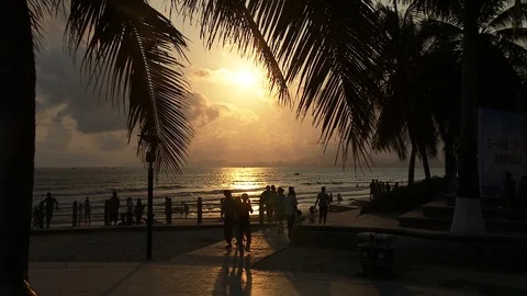 Tourists strolling on the beach at sunset Stockbeeldmateriaal 88889512