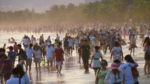 Tourists strolling on the crowded beach at sunset Stock Footage 88887881