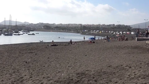 Tourists sunbathing on the Playa de las Galletas beach in Costa del Silencio Video stock 80617211