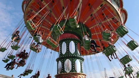 Tourists swing high on a spinning carousel ride at the amusement park. Stock Footage 339246577