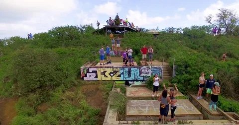 Tourists take photos atop a mountain as the camera flies away Stock Footage
