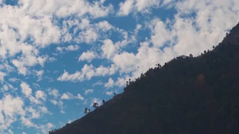 Tourists taking off on parachute from mountain in front of the clouds at Manali  Stock Footage 171321544