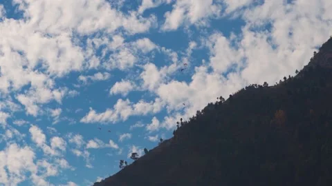Tourists taking off on parachute from mountain in front of the clouds at Manali  Stock Footage 171321545