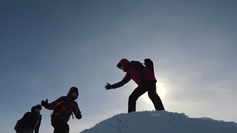Tourists teamwork, climbing the mountain, helping each other, reaching the top Stock Footage 103147207