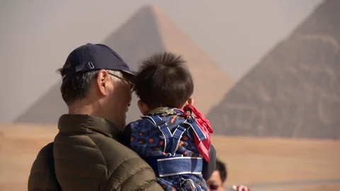 Tourists on a viewing platform in front of the pyramids of Giza. Elderly man sho Stock Footage 76214133