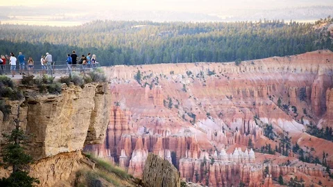 Tourists at viewpoint cliff at Bryce Point national park overlook view sunset Stock Footage 120605446