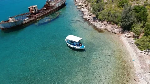Tourists visit the rusty shipwreck of an old cargo boat at Peristera islet ne Stock Footage 201446471