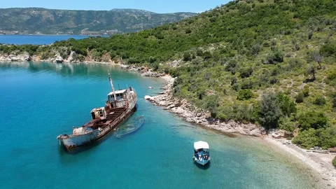 Tourists visit the rusty shipwreck of an old cargo boat at Peristera islet ne Stock Footage 201449701