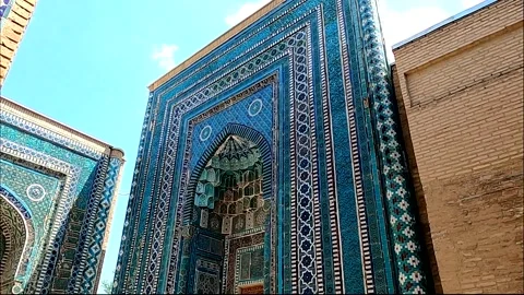 Tourists visiting historic blue tile mausoleums at Shah-i-Zinda, Samarkand Stock Footage 336743127