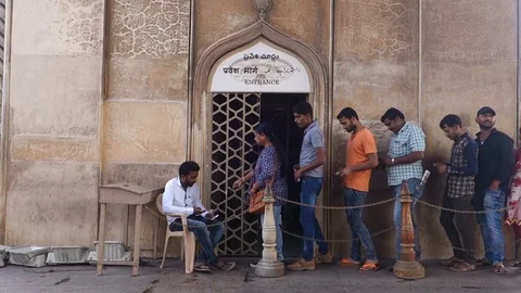Tourists wait in line while a staff member collects tickets at the entrance door Stock Footage 83641094