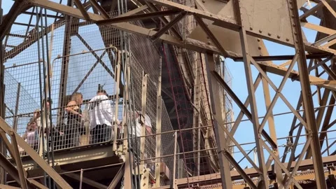 Tourists waiting for elevator inside Eiffel Tower structure 스톡 동영상 334134016