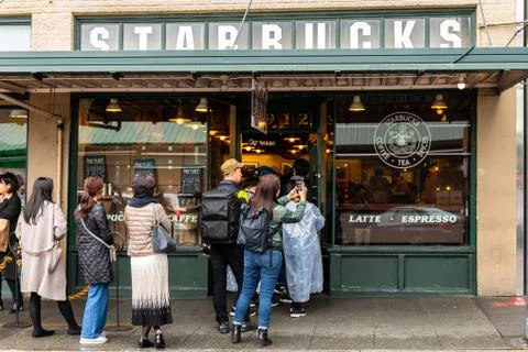 Tourists waiting in long queue to get in first Starbucks shop. Stock Photos
