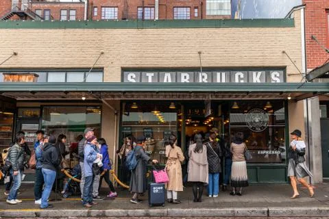 Tourists waiting in long queue to get in first Starbucks shop. Stock Photos