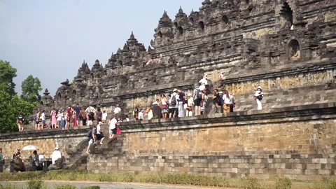 Tourists walk up the ancient stone steps and terraces of Borobudur 스톡 동영상 341676363