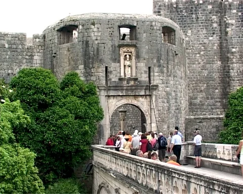 Tourists walk on bridge to Pile Gate of old city Dubrovnik Stock Footage 106607133