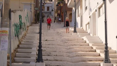 TOURISTS WALK DOWN WHITE STEPS SITIA CRETE GREECE Video stock 70703789