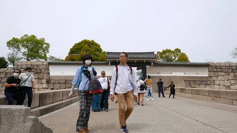 Tourists walk in Osaka Castle through otemon western gate, Japen Stock Footage 90643633