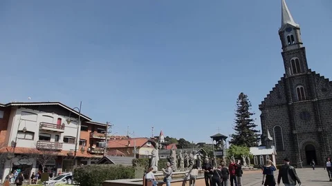 Tourists walk on the square in front of the Stone Church in Gramado, Brazil Stock Footage 79427249