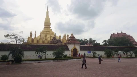Tourists walk through temple gate, golden temple, Wat Sisaket, Laos Vídeos de archivo 75002553