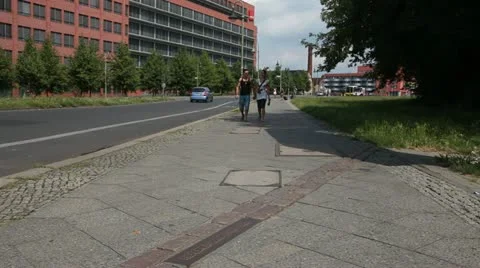 Tourists walking across the old border at the Berlin Wall in Kreuzberg Vídeo Stock 11515280