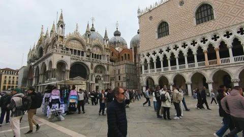 Tourists walking across St. Marks Square, near the famous St. Marks Basilica and Vidéo 320796412