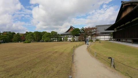 Tourists walking along a path in the beautiful garden of Nijo Castle in Kyoto Stockbeeldmateriaal 333705813