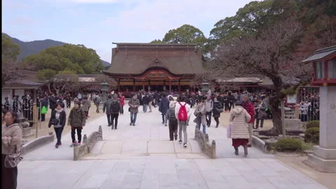 Tourists walking along a pathway flanked by lanterns in Dazaifu Shrine Stock Footage 247665091