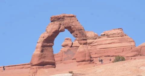 Tourists walking around the Delicate Arch in Arches National Park, Utah Stockbeeldmateriaal 303406699