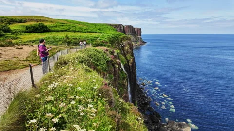 Tourists walking around on the tall cliffs of Kilt Rock in Isle of Skye Stock Footage 342589571