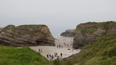 Tourists walking on beach between cliffs Stock Footage 300648177