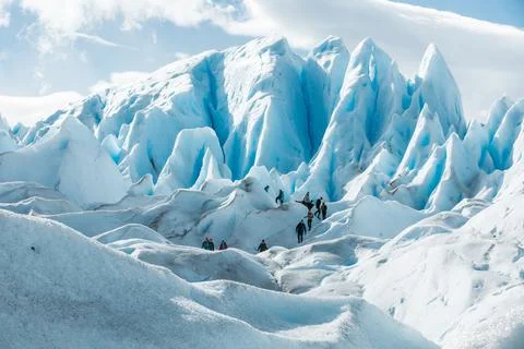 Tourists walking between the layers of ice formation of Perito Moreno Glacier Stock Photos