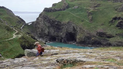 Tourists walking on cliff path to tintagel castle Stock Footage 280717461