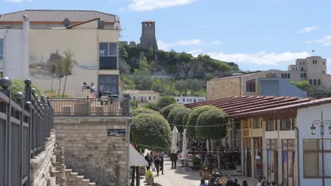 Tourists walking on cobblestone street below Kruje Castle Albania Stock Footage 345679782