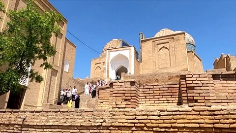 Tourists walking down the ancient stairs at Shah-i-Zinda complex, Samarkand Vidéo 336679251