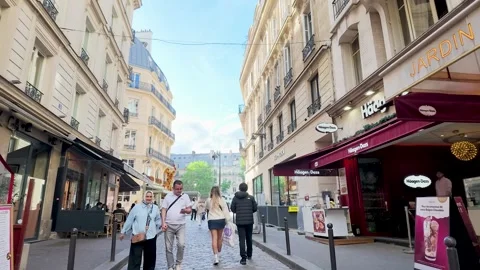 Tourists Walking Down a Narrow Cobblestone Street in Paris France Stock Footage 335797571