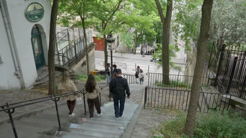 Tourists walking down stone stairs in historic Montmartre district of Paris Vídeos de archivo 336723421