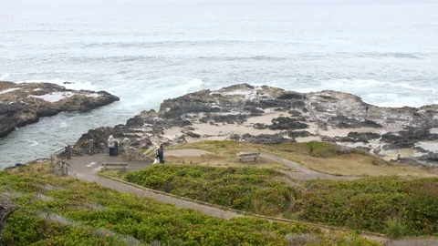 Tourists walking down to Thor's Well in Cape Perpetua Oregon Stock Footage 147693351