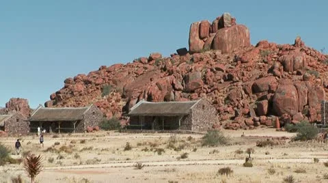 Tourists walking in front of granite boulders Stock Footage