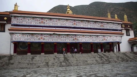 Tourists walking past the Labrang Monastery in Xiahe, China Stock Footage 72510125