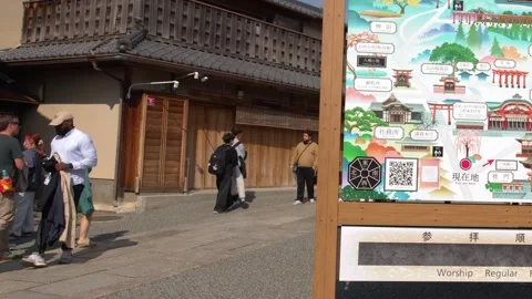 Tourists Walking Past a Large Map Sign at a Japanese Temple Stock Footage 337533159
